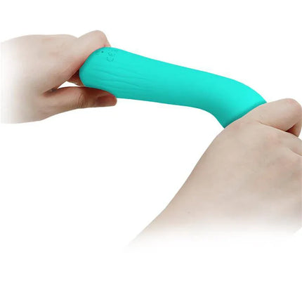 Hands holding and bending the Faun Vibrator Green, showcasing its flexibility and soft silicone texture.