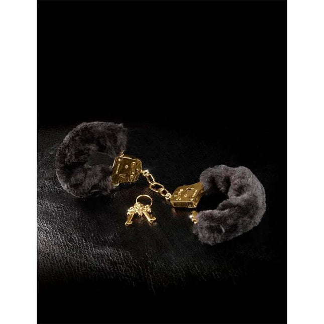 Fetish Fantasy Gold Deluxe Furry Cuffs Gold on a dark background, showcasing the gold-tone opulent finish and black fur design.