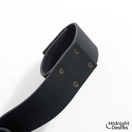 Detailed view of the Flexible Bondage Bar cuff from Midnight Desires, featuring vegan leather and metal hardware for secure restraint.