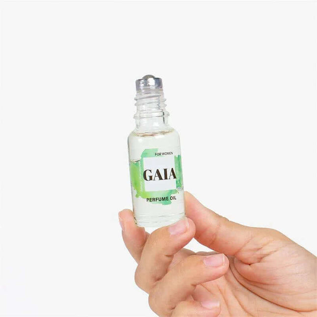 Hand holding Gaia Natural Pheromones Perfume Oil Roll-On 20 ml with citrus-infused fragrance.