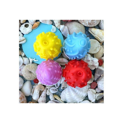 Colorful textured toys on seashell backdrop, featuring the red Gegg Masturbator Egg Red.