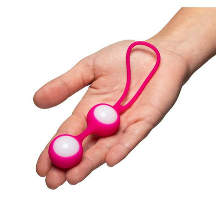 Hand holding Geisha Balls Level I (2x18 gr) silicone vaginal balls with string; ideal for pelvic floor exercise and intimate preparation.