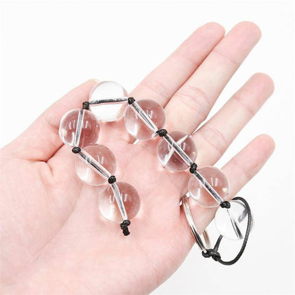 Hand holding Glass Anal Beads 4 Sizes from Latetobed BDSM Line, featuring crystal glass beads for intense pleasure and exploration.