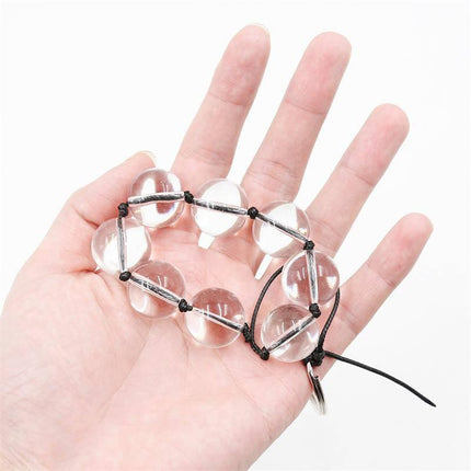 Hand holding Glass Anal Beads 4 Sizes in crystal glass for BDSM pleasure and varying stimulation.