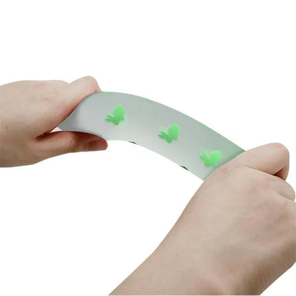 Hands holding Glow in the Dark Dildo with Suction Cup and Harness, showcasing flexible and luminous bunny shapes.