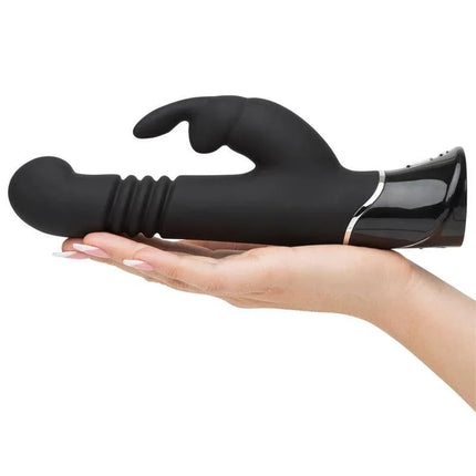Hand holding black Greedy Girl Rechargeable Thrusting G-Spot Rabbit V vibrator for dual stimulation