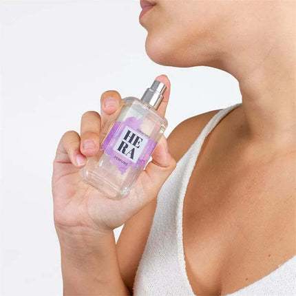 Woman holding Hera Natural Pheromones Perfume 50 ml, floral-fruity fragrance for enhancing allure and confidence with natural pheromones.