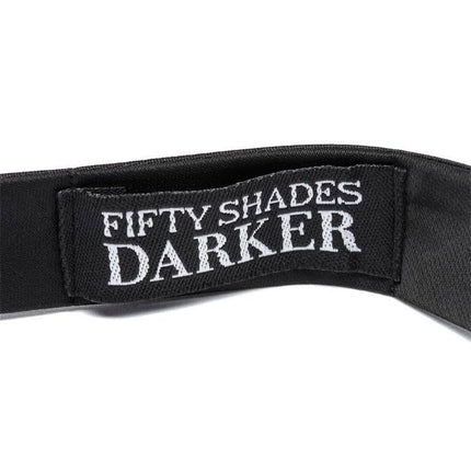 Close-up of the Fifty Shades Darker tag on the His Rules Bondage Bow Tie, featuring silky, luxurious fabric.
