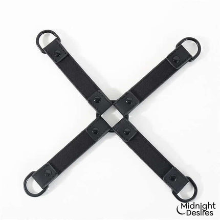 Hogtie Cross Bar Hand and Ankle Cuffs in vegan leather by Midnight Desires, showing a black cross-shaped spreader for restraint.
