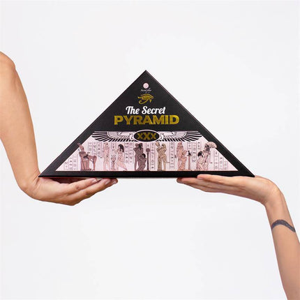 Juego The Secret Pyramid board game held in hands, featuring a pyramid-shaped box with Egyptian design and explicit content warning.