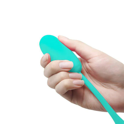 Hand holding Julius Vibrating Egg Green, showcasing its compact size and soft silicone texture for pleasure.