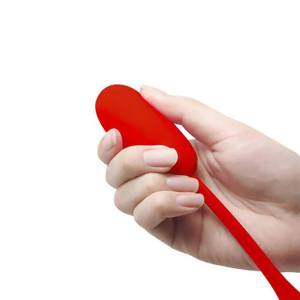 Hand holding Julius Vibrating Egg Red, a silicone sexual wellness product with 12 vibration settings, suitable for solo pleasure.