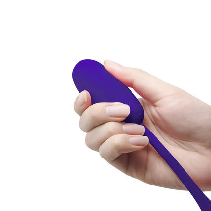 Hand holding Julius Vibrating Egg Violet with quilted silicone texture for enhanced sensations in bath or bed.