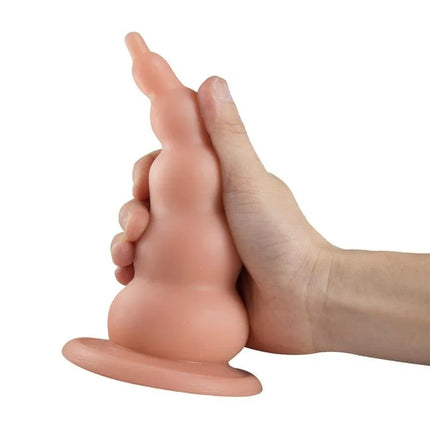 Hand holding Kai Adaptable Butt Plug Flesh 9,4 - 18.4 cm, showcasing its ascending diameter design for comfort and secure fit.