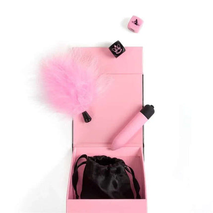 Kit Secret Pleasures Box featuring a pink vibrating bullet, pink feather duster, dice, and black satin pouch for intimate moments.