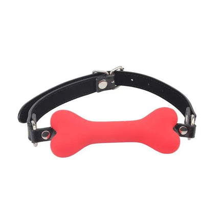 Red bone-shaped silicone ball gag from Kit Serve Me Silicone set with adjustable black PU straps.
