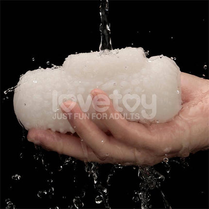 Hand holding Knights Ring Vibrating Dual Purpose Sleeve Drip with water cascading, showcasing texture and design for enhanced pleasure.