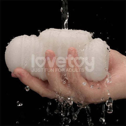 Hand holding wet Knights Ring Vibrating Dual Purpose Sleeve Wavy under water streams, showcasing texture and flexibility