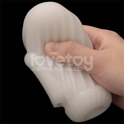 Close-up of hand holding Knights Ring Vibrating Dual Purpose Sleeve in white, showcasing its soft and flexible texture for versatile pleasure.