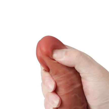 Close-up of hand squeezing Leo Dildo Double Hardness Dual Layer Silicone 9.44, showcasing soft exterior and realistic texture.