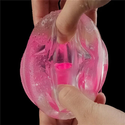 Hands holding the Lumino Play Masturbator Pink Glow 8.5 showcasing its textured interior and glow-in-the-dark pink design.