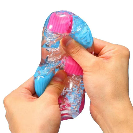Hands squeezing Masturbator Bobble Crazy Cubes, a flexible and colorful manual masturbator for self-exploration or partner play.