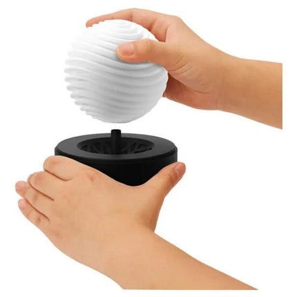 Hands holding the Masturbator Geo Aqua with nature-inspired wave design and drying stand by Tenga.