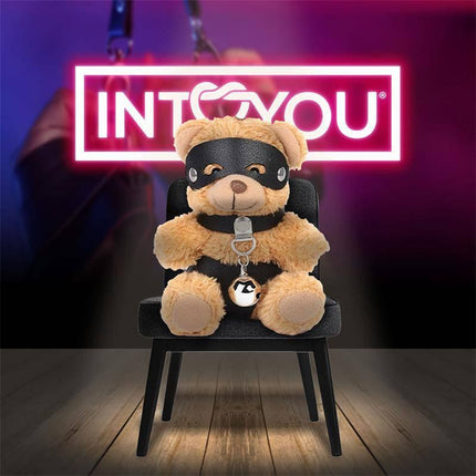 Mimi Keychain BDSM Teddy Bear with Collar and Bell sitting on a chair, featuring a playful design with a mask and vegan leather collar.