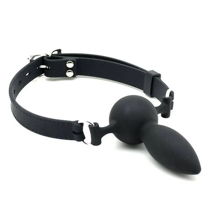 Mouthgag with Plug Silicone - black silicone mouth gag with metal buckle and adjustable strap for secure restraint.