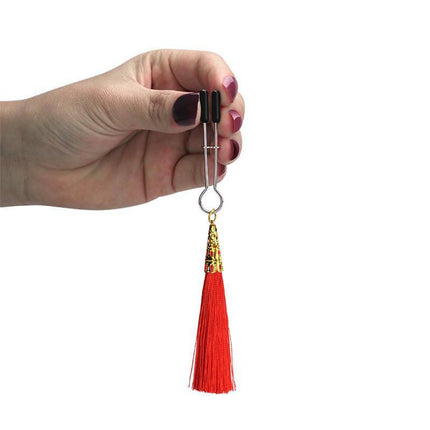 Hand holding Nipple Clamps Red with glamor red tassel and silicone tips for intimate play.