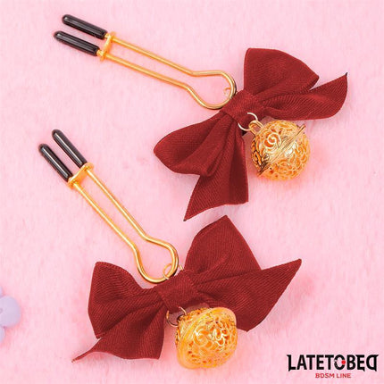 nipple clamps with Bow from Latetobed BDSM Line featuring adjustable clamps and decorative bells on pink background