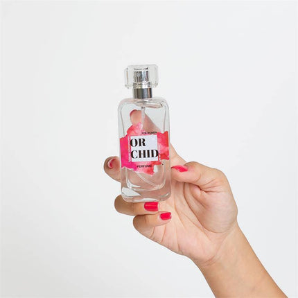 Hand holding a 50 ml bottle of Orchid Natural Perfume with Pheromones Spray, featuring a sleek design and vibrant label.