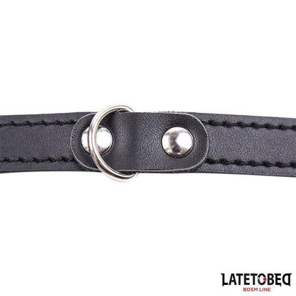 Close-up of black adjustable strap detail on Penis Cage Adjustable device, made of black PVC and metal for discreet intimacy.