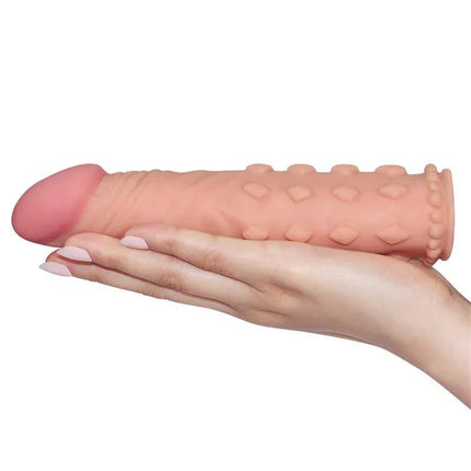 Hand holding Penis Sleeve Add 2 Pleasure X Tender Flesh by LoveToy, featuring lifelike design with textured shaft for enhanced stimulation.