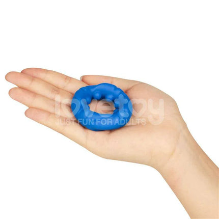 Hand holding a Pinnacle Pro Ridge Bump Stretcher Penis Ring in blue, showcasing its compact and flexible design for enhanced stamina.