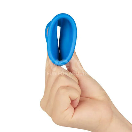 Hand holding blue Pinnacle Pro Tapered Squeeze Stretcher Penis Ring, showcasing flexible silicone design.
