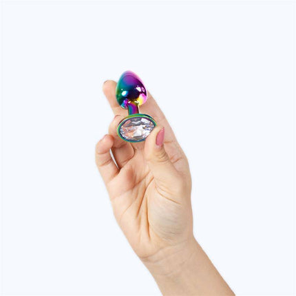 Hand holding a Rainbow Metal Butt Plug Size S with jewel base and colorful finish.