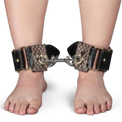Person wearing Rebellion Reign Ankle Cuffs with vintage-style bronze spikes for bondage enthusiasts.