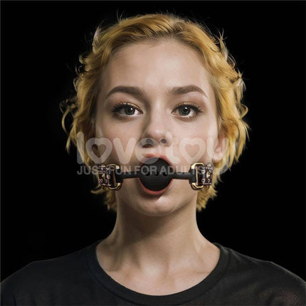 Rebellion Reign Breathable Silicone Ball Gag worn by model with antique bronze spikes on dark brown faux leather strap