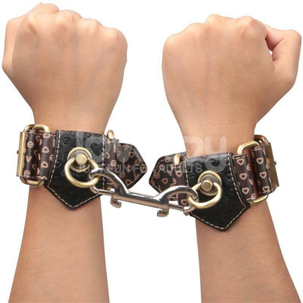 Rebellion Reign Handcuffs on wrists, showcasing luxurious leather-inspired design with durable PU material for couples' play.