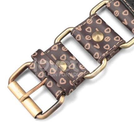 Close-up of a decorative brown belt with heart patterns and a brass buckle.