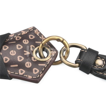 Close-up of the Rebellion Reign Love Paddle 15 dual-surface with rings and printed design, showcasing ergonomic features for diverse intimacy.