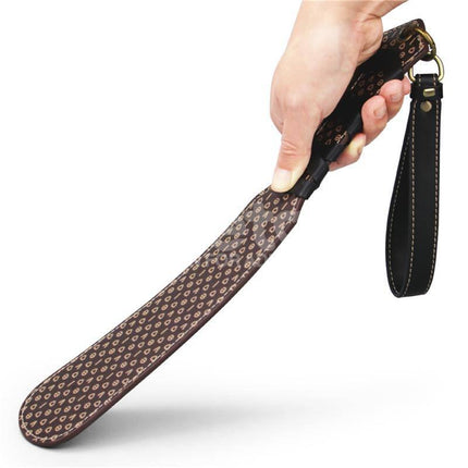 Person holding Rebellion Reign Love Paddle 15 with dual-surface design, showcasing ergonomic grip for customizable intimacy.