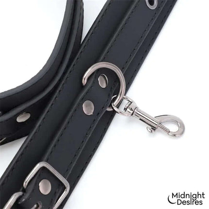 Restrain Set with Hand and Thigh Cuffs featuring sleek black leather and metal clasp for secure and adjustable restraint.