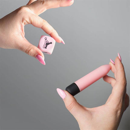 Hands holding Sensual Feelings Kit Vibrating Bullet and Dice Postures with pink bullet and posture dice, enhancing intimate moments.