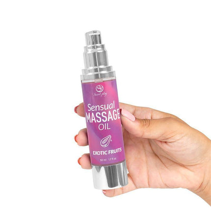 Hand holding a bottle of Sensual Massage Oil Exotic Fruits 50 ml for relaxation and intimate moments.
