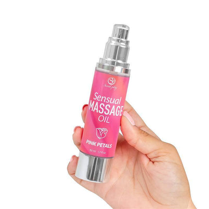 Hand holding Sensual Massage Oil Pink Petals 50 ml bottle for intimate relaxation and skincare.