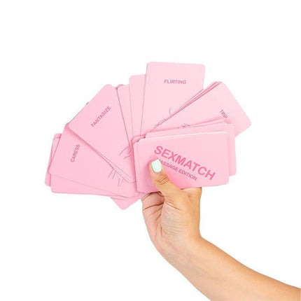 Hand holding pink cards from Sexmatch Game Massage Edition, a couples' card game with challenges, featuring various words and illustrations.