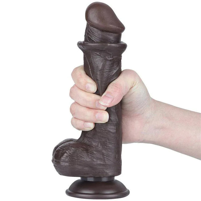 Hand holding the Sliding Skin Dual Layer Dildo 8 featuring lifelike texture and suction base for realistic stimulation experience.