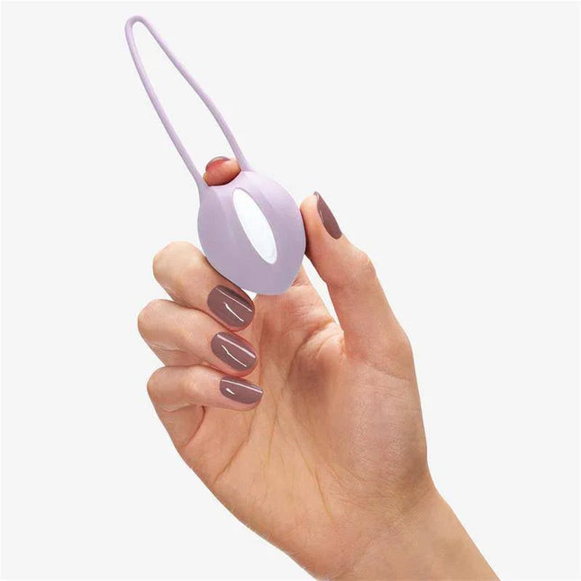 Hand holding Smartball uno Kegel Ball White/Pastel Lilac for pelvic floor strengthening and pleasure enhancement.